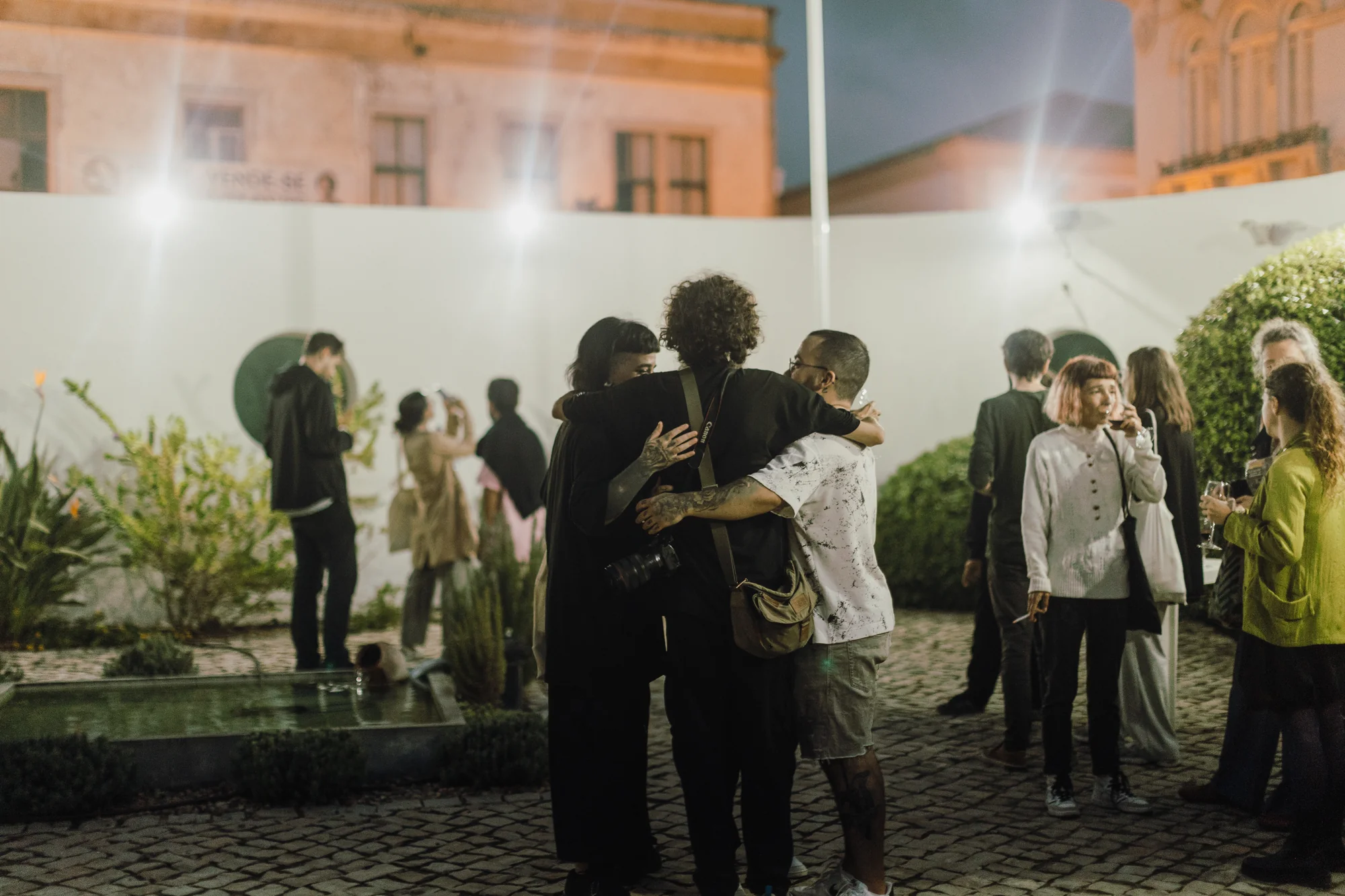 Grupo em abraço caloroso durante a noite de encerramento no consulado